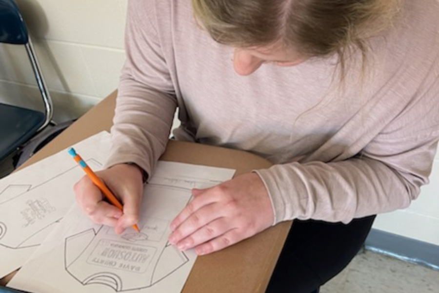 Pic of Sports & Entertainment Marketing student Autumn Harbour who is one of the winners of the event's t-shirt design contest drawing a t-shirt design.