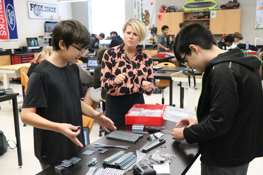 (L to R) Lucas Smith and Hayden Jambor, students in Will Miner’s mechatronics class, show Superintendent Truitt VEX Robotics parts purchased through a $14,000 grant from Ashley Furniture.