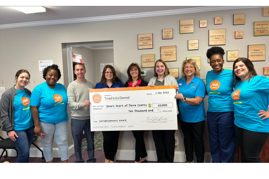 (Left to Right) Jenna Stottler, Jessica Ford, Thomas Johnson, Tara Dodson, Tracy Kuhnemann, Allison Gupton, Harriet Wood,  Dr. Kasheena Hollis, DMD, and Renee Young of Triad Kids' Dental  present Smart Start of Davie County with a check for $10,000. 