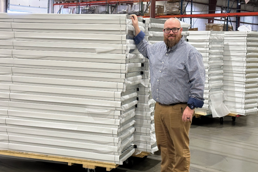 Safety and Training Manager Justin Norris shows a stack of door sections ready to be shipped for assembly. 
